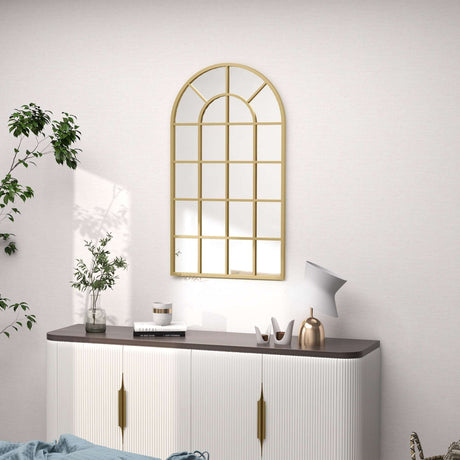 Stylish gold-framed wall mirror in an arch design above a modern sideboard for elegant bathroom decor