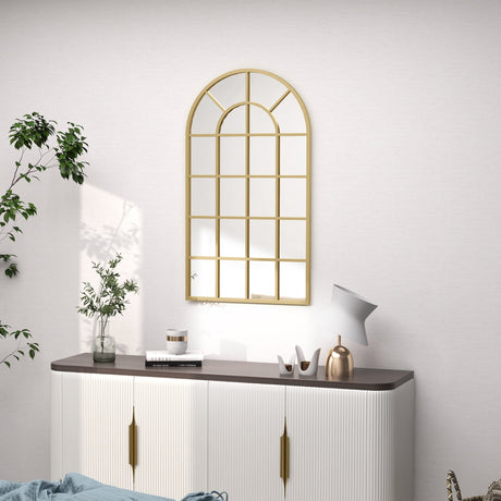 Stylish gold-framed wall mirror in an arch design above a modern sideboard for elegant bathroom decor