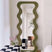Nisu Home Wall Mirror with a wavy green frame, adding a unique touch to modern interiors