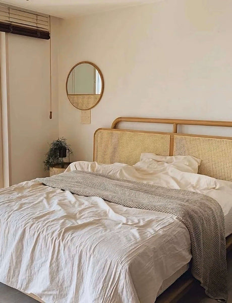 Nisu Home Wall Mirror above a styled bed with natural textures and neutral tones