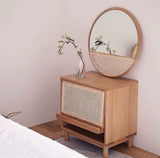Round Wall Mirror above a natural wood cabinet with a minimalist design by Nisu Home