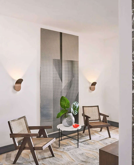 Stylish Nisu Home Wall Sconce illuminating a modern lounge with wooden chairs and minimalist decor