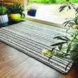 Striped washable mat placed near plants by a garden entrance for a stylish home decor