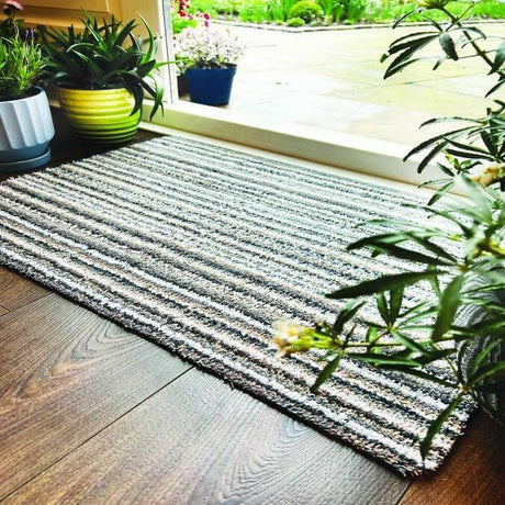 Striped washable mat placed near plants by a garden entrance for a stylish home decor