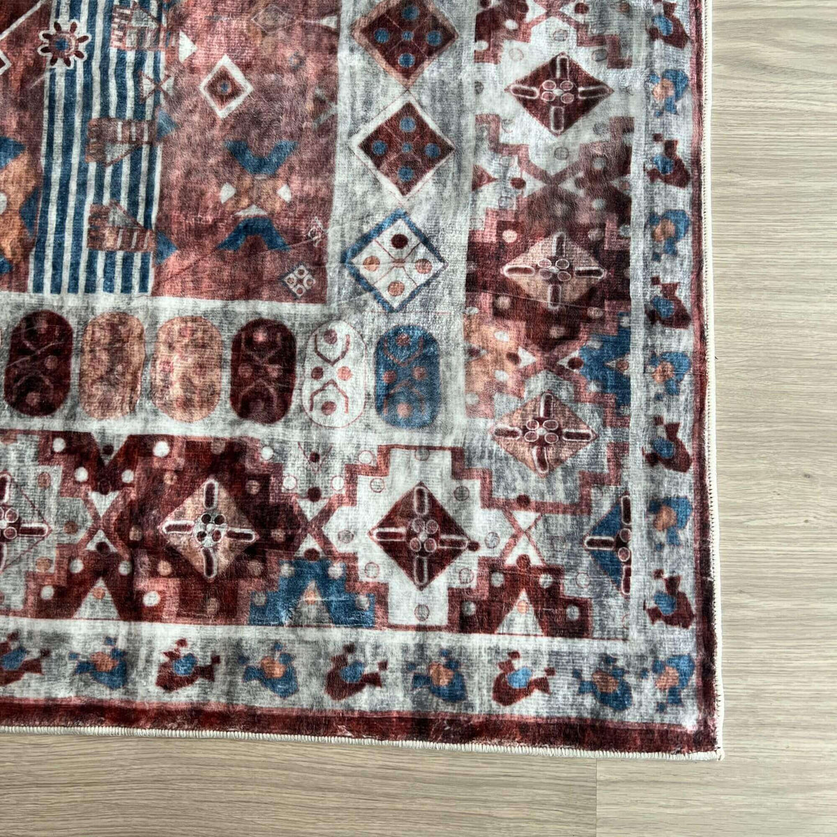 Decorative washable rug featuring intricate patterns in rich reds and blues for stylish interiors