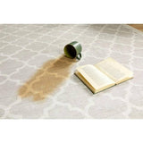 Stylish grey and cream washable rug with a geometric pattern and a book and mug on top