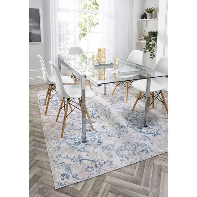 Stylish washable rug under a glass dining table with white chairs, perfect for modern interiors