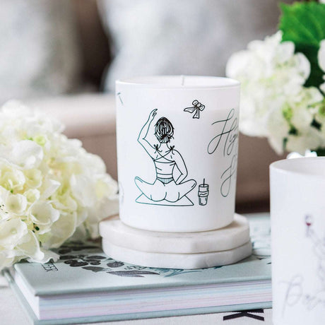 Avalon Home UK Wax Glass Candle featuring elegant artwork and surrounded by decorative flowers