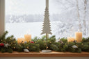 Elegant tree on stand decoration with white candles and festive greenery for Christmas room decor