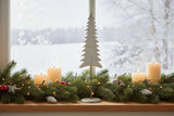 Elegant tree on stand decoration with white candles and festive greenery for Christmas room decor