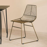 Orsina Wire Chair in bronze with geometric design paired with a minimalist black table