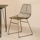 Orsina Wire Chair in bronze with geometric design paired with a minimalist black table