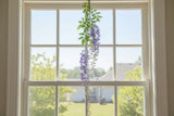 Artificial Wisteria Spray hanging in a sunny window, adding a touch of floral elegance to home decor