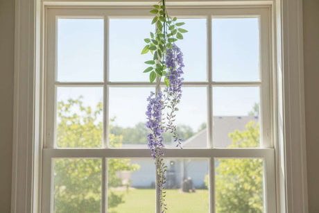 Artificial Wisteria Spray hanging in a sunny window, adding a touch of floral elegance to home decor