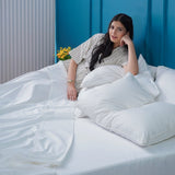 SHEET STORY Flat Sheet on a bed with pillows and a person relaxing, showcasing comfort and style