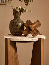 Orsina Wood Sculpture on a tabletop alongside a decorative vase and greenery