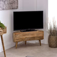 Verty Furniture Corner TV Stand in natural wood finish with a TV and decorative plants in a modern living room