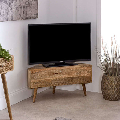 Verty Furniture Corner TV Stand in natural wood finish with a TV and decorative plants in a modern living room