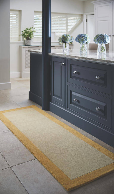 Wool Rug with a cream centre and yellow border placed by a kitchen island