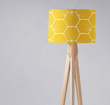 Bright yellow geometric lampshade for modern decor on a wooden tripod lamp